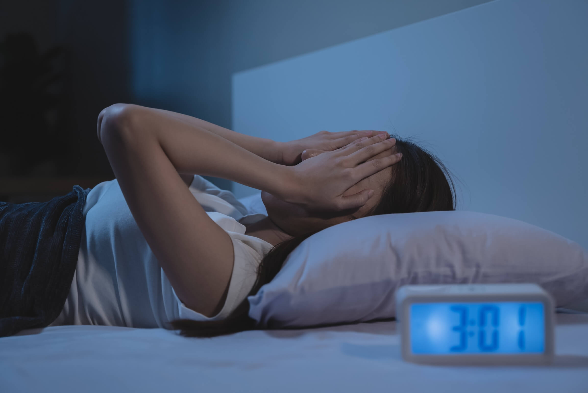 Kobieta cierpi na bezsenność na łóżku
